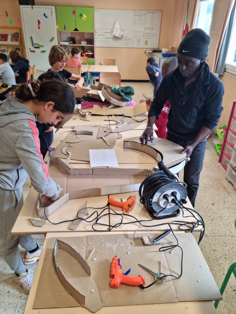 Équipe Garibaldi aux champs, au moulin, aux fours, et même au service de table ! Arrière plan: Atelier d'Invention / Rédaction des poèmes, sujet Banane.