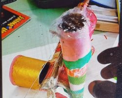 Meilleure invention / production.
Enfant nettement plus éveillée, curieuse, engagée, patiente, courageuse, volontaire que ses camarades de classe, et ses ainés du CE1 au CM2 actifs sur cette longue activité.
Résultat: Joie, admiration, envie et plaisir de le toucher / d'en jouer par tous les autres enfants, & des collègues animateurs. Présentation: 3/4 du GratOuf. La Photo de l'instrument achevé n'existe malheureusement pas. En effet, j'étais brusquement affecté sur une sortie plage, (en remplacement d'un collègue malade). En mon absence, la petite avait achevé l'assemblage de son "GratOuf" avec mes collègues restés au centre, et s'en était allée en vacances ! Un programme familial inattendu.