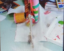 Meilleure invention / production.
Enfant nettement plus éveillée, curieuse, engagée, patiente, courageuse, volontaire que ses camarades de classe, et ses ainés du CE1 au CM2 actifs sur cette longue activité.
Résultat: Joie, admiration, envie et plaisir de le toucher / d'en jouer par tous les autres enfants, & des collègues animateurs. Description de l'instrument. 1er plan: Petit tambour en boite métallique couverte de peau en morceau de ballon de baudruche rose. Ensemble fixé sur une Caisse de résonance; une autre boite métallique plus grande et longue, décorée de bandes de pailles. Au centre, un bout de la tige principale en bambou, servant de Manche à l'instrument. Le Manche porte les cordes en nylon. Coté opposé, (visible d'ici): Un gros micro en boite plus fine et longue, couverte de film plastique très fin qui vibre facilement au son de la voix. La Photo de l'instrument achevé n'existe malheureusement pas. En effet, j'étais brusquement affecté sur une sortie plage, (en remplacement d'un collègue malade). En mon absence, la petite avait achevé l'assemblage de son "GratOuf" avec mes collègues restés au centre, et s'en était allée en vacances ! Un programme familial inattendu.